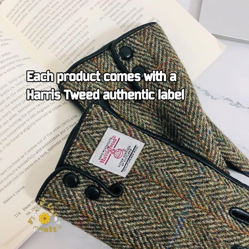 Op de afbeelding: Close-up van een paar vingerloze handschoenen van bruin en groen tweed met zwarte leren afwerking en zwarte knopen. De handschoenen hebben een label met de tekst "Harris Tweed" met daaronder de woorden "Outer Hebrides of Scotland". De tekst "Each product comes with a Harris Tweed authentic label" is over de afbeelding gelegd.