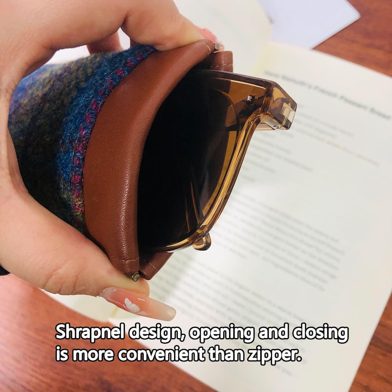 May include: Brown leather and patterned fabric glasses case holding brown-tinted sunglasses. The case has a shrapnel design for easy opening and closing. Text on the image reads: Shrapnel design, opening and closing is more convenient than zipper.