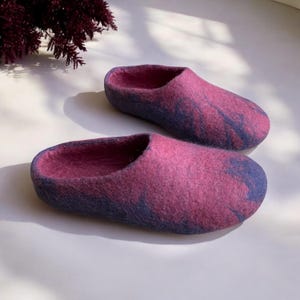 May include: A pair of purple and blue wool slippers. The slippers are made of felted wool and have a soft, comfortable feel.