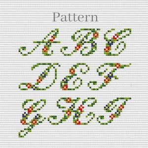May include: Cross-stitch pattern featuring the letters A through N, each adorned with green vines and colorful floral accents. The word "Pattern" is displayed at the top. The design is on a white grid background.