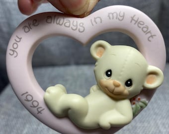 Puede incluir: Un adorno de corazón rosa con un osito de peluche blanco en su interior. El adorno dice "You are always in my heart 1994".