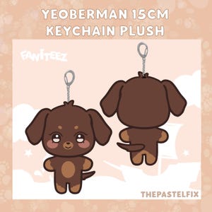 May include: A brown and tan Yeoberman keychain plush, approximately 6 inches tall, with a silver keychain attachment. The plush has large, expressive eyes and is shown from the front and back. Text on the image reads "YEOBERMAN 15CM KEYCHAIN PLUSH" and "FANITEEZ".