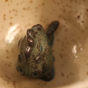 Hand-thrown, hand-glazed mug/ coffee mug/ tea mug/ clay mug/ ceramic mug with a fired-on dinosaur on the bottom/ grumpy morning mug