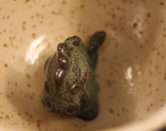 Hand-thrown, hand-glazed mug/ coffee mug/ tea mug/ clay mug/ ceramic mug with a fired-on dinosaur on the bottom/ grumpy morning mug