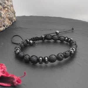 May include: Black lava rock beaded bracelet with silver metal accents and a black cord.