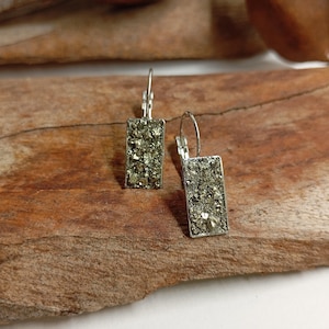 May include: A pair of silver dangle earrings with rectangular shaped pyrite stones.