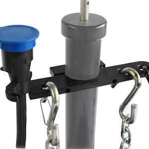 May include: A black plastic cord holder with two hooks and a blue cap on a black cord. The holder is attached to a gray pole with the text "PLUG SAVER" printed on the holder.