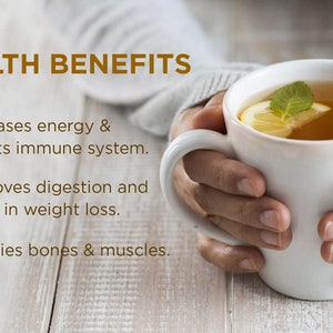 May include: A white mug with a lemon slice and a sprig of mint in it. The mug is filled with a light brown liquid. The text "HEALTH BENEFITS" is at the top of the image. Below the mug, there are three bullet points with check marks. The bullet points list the health benefits of the drink: increases energy and boosts the immune system, improves digestion and helps with weight loss, and fortifies bones and muscles.
