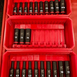 May include: A red toolbox containing a set of black sockets. The sockets are labelled with measurements in inches, ranging from 3/16 to 9/16. The toolbox is organised into three layers.