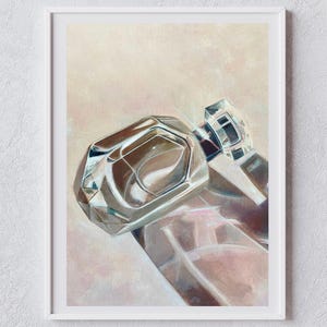 May include: A framed painting of a clear glass perfume bottle with a faceted, geometric stopper. The artwork features soft, muted tones of beige, cream, and pale pink, capturing the light reflections and transparency of the glass bottle.