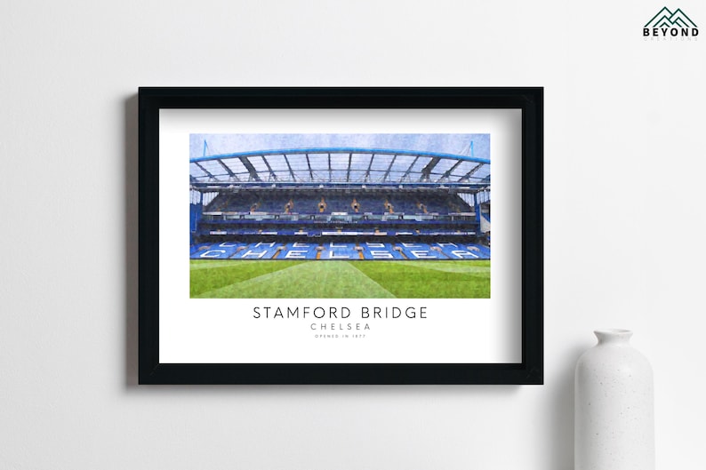 May include: A framed print of Stamford Bridge, the home of Chelsea Football Club. The image shows the stadium's exterior with a blue and white color scheme. The text "Stamford Bridge, Chelsea, Opened in 1877" is printed below the image.