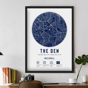 Pu&ograve; includere: Una stampa incorniciata di una mappa di Millwall, Londra, Inghilterra. La mappa &egrave; di colore blu navy ed &egrave; circondata da un bordo bianco. Il testo "The Den" &egrave; stampato sotto la mappa, insieme alle coordinate 51&deg;29'09.4"N 0&deg;03'03.2"W. Il testo "Millwall" &egrave; stampato sotto le coordinate.