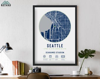 May include: A framed print of a map of Seattle, Washington, with a blue and green color scheme. The map shows the city's streets and landmarks, including the Seahawks Stadium. The print includes the city's coordinates and the text "Seattle Seahawks Stadium".