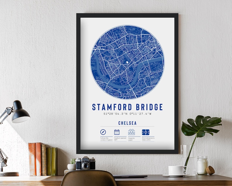 May include: A blue and white map print of Stamford Bridge, a football stadium in Chelsea, London, England. The print includes the stadium's coordinates and the text "Stamford Bridge" and "Chelsea".