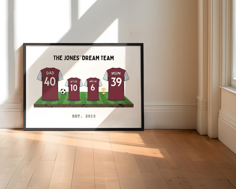 May include: Framed print featuring a family's soccer jerseys on a green field. The jerseys are maroon with white sleeves and include the names and numbers of each family member. The text "THE JONES' DREAM TEAM" and "EST. 2015" are also displayed.