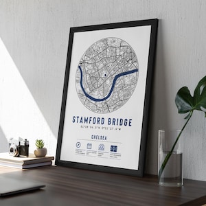 May include: Black and white map print of Stamford Bridge in Chelsea, London, England. The map is in a black frame and shows the area around the stadium. The text "STAMFORD BRIDGE" and "CHELSEA" is printed below the map.
