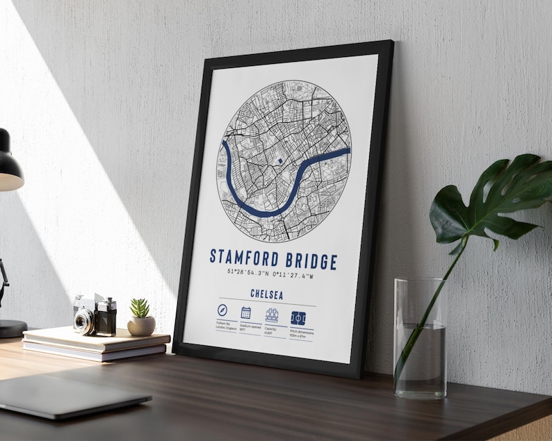 May include: Black and white map print of Stamford Bridge in Chelsea, London, England. The map is in a black frame and shows the area around the stadium. The text "STAMFORD BRIDGE" and "CHELSEA" is printed below the map.