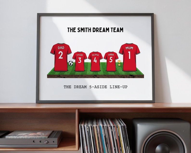 May include: Framed print featuring red soccer jerseys with names and numbers, arranged on a green field. The text reads "THE SMITH DREAM TEAM" and "THE DREAM 5-ASIDE LINE-UP". A soccer ball and trophy are also included.