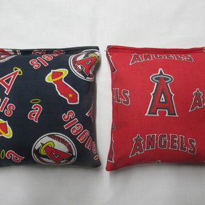 May include: Two square bean bags. One is navy blue with red and white Angels logos and text. The other is red with white Angels logos and text. Both are filled and ready for play.