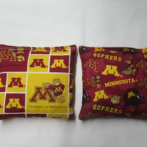 May include: Two red and gold bean bags with the University of Minnesota logo and the word "Gophers".