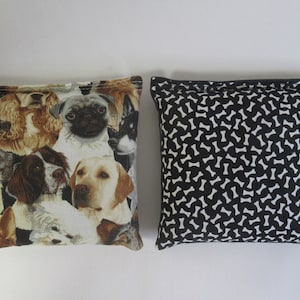 May include: Two square fabric pouches. One features a collage of various dog breeds in shades of brown, tan, and white. The other has a black background with a white bone pattern.