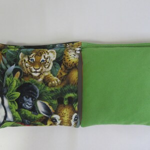 May include: A green bean bag with a jungle animal print on one side. The print features a tiger, a monkey, a giraffe, and a zebra.