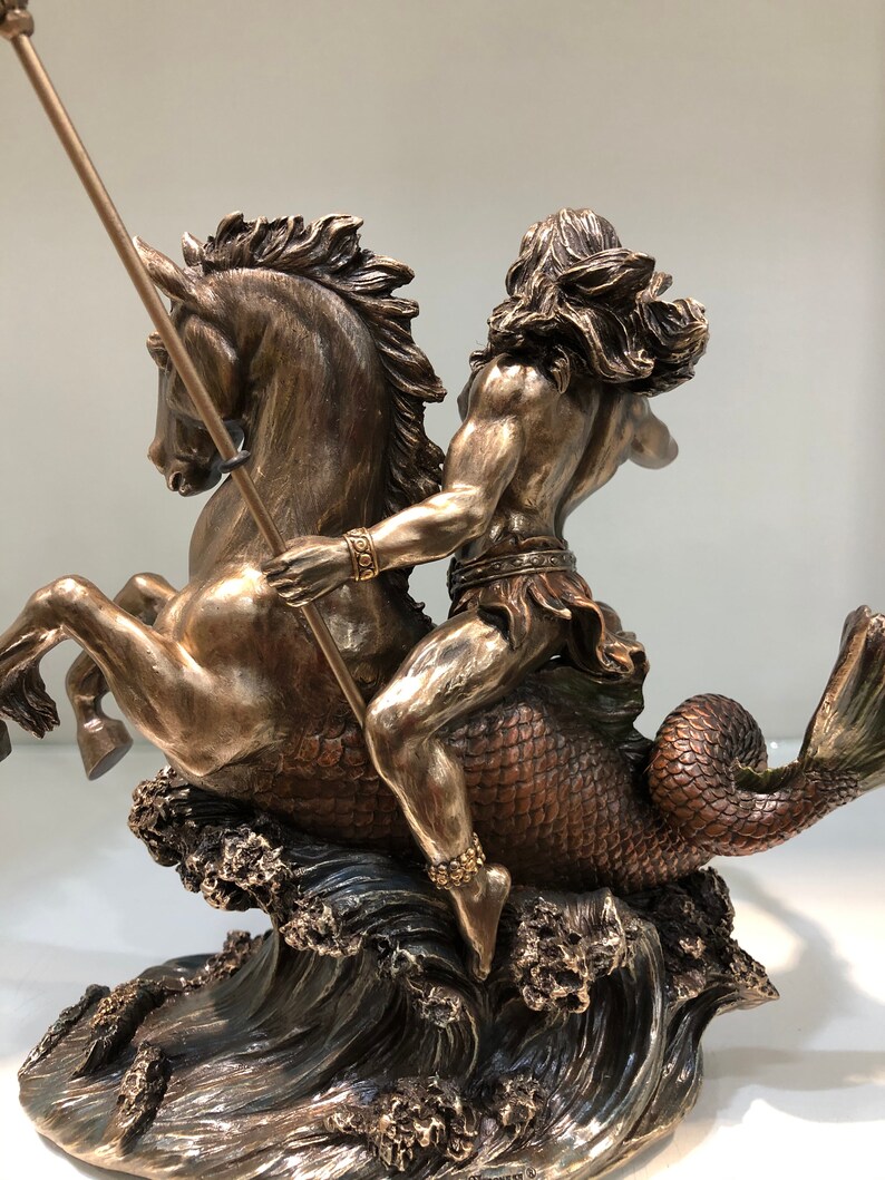 K&ouml;nnte beinhalten: Bronzeskulptur, die eine mythologische Figur zeigt, die ein Seepferd reitet. Die Figur mit langem Haar und einem Speer ist muskul&ouml;s und detailliert. Das Seepferdchen hat einen Pferdekopf und einen Fischschwanz, mit Wellen an der Basis.