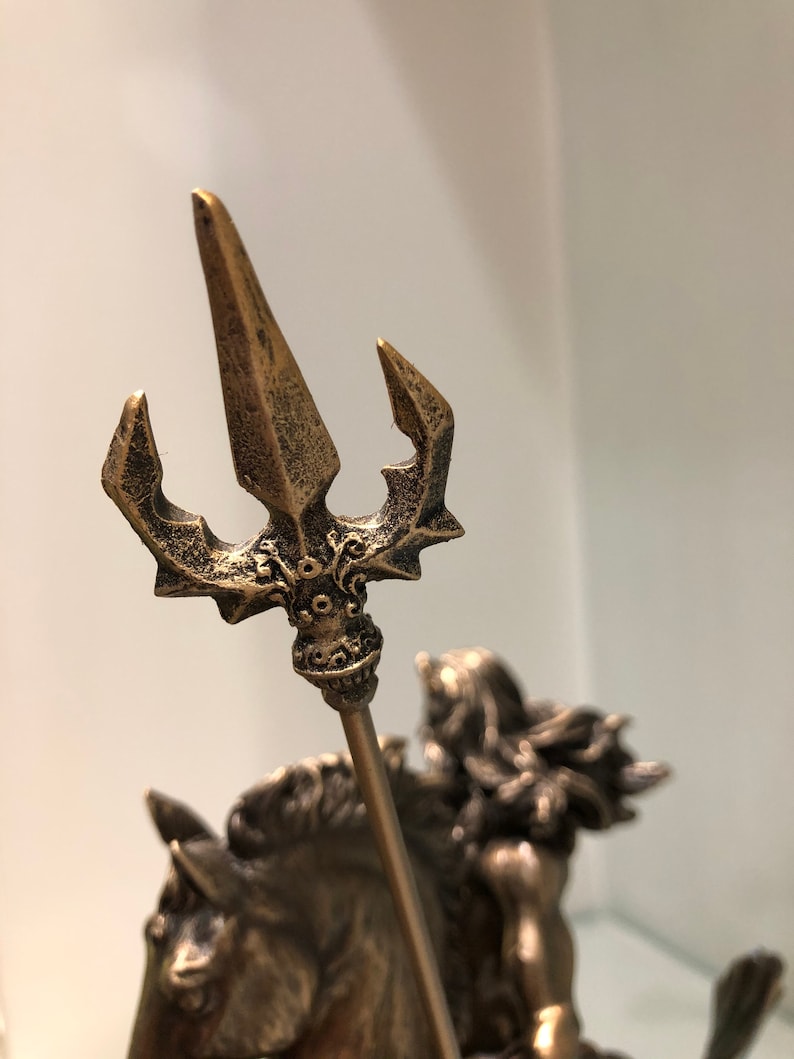 K&ouml;nnte beinhalten: Bronzestatue einer Figur auf einem Pferd, die einen Dreizack h&auml;lt. Der Dreizack hat drei Zinken und aufwendige Details. Die Statue hat ein verwittertes Aussehen, das auf einen antiken Stil hindeutet. Auch das Haar der Figur und die M&auml;hne des Pferdes sind detailliert.