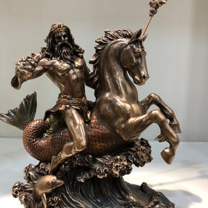 K&ouml;nnte beinhalten: Bronzestatue von Poseidon, der ein Seepferd reitet und einen Dreizack h&auml;lt. Die Statue zeigt detaillierte Darstellungen des Meeresgottes, des Pferdes und der Wellen. Ein Delphin schwimmt in den Wellen. Die Basis der Statue tr&auml;gt die Aufschrift "POSEIDON".