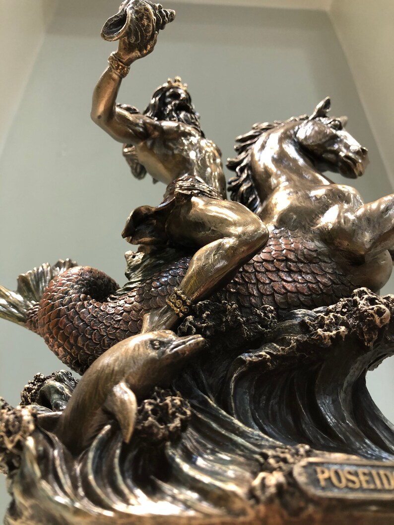 K&ouml;nnte beinhalten: Bronzestatue von Poseidon, der ein Seepferd reitet und eine Muschel hochh&auml;lt. Ein Delphin schwimmt in den Wellen darunter. Die Statue hat komplizierte Details und ist auf einem Sockel mit dem Namen "Poseidon" montiert.