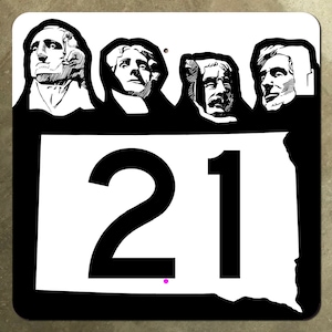 May include: A black and white sign featuring the faces of four presidents above the number 21. The sign is shaped like the state of South Dakota. The sign has a black border.