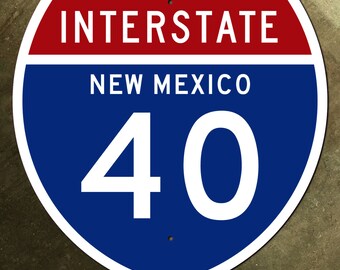 Könnte beinhalten: Ein blaues und rotes Interstate-Straßenschild mit weißem Text. Das Schild lautet "Interstate New Mexico 40".