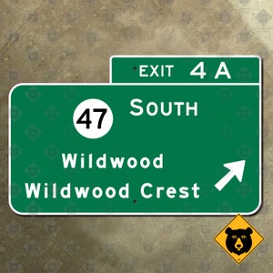 May include: A green highway sign with white text indicating Exit 4A, South, Wildwood, and Wildwood Crest. A white arrow points right. A yellow bear warning sign is in the lower right corner.