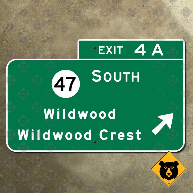 May include: A green highway sign with white text indicating Exit 4A, South, Wildwood, and Wildwood Crest. A white arrow points right. A yellow bear warning sign is in the lower right corner.