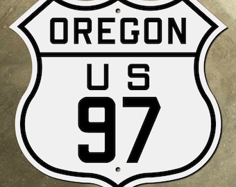 May include: White and black US highway sign with the text "OREGON US 97" on it.