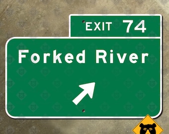 May include: A green road sign with white text that reads "Forked River" and "Exit 74". A white arrow points to the right. A yellow bear warning sign is in the lower right corner. The background is a textured, neutral color.