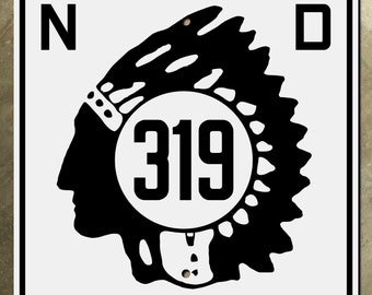 Könnte beinhalten: Ein schwarz-weißes Schild mit einem Profil eines indianischen Kopfes, der eine Kopfbedeckung trägt. Die Nummer 319 befindet sich in einem Kreis in der Mitte des Schildes. Die Buchstaben N und D befinden sich in den oberen Ecken des Schildes.