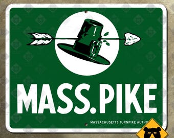 May include: Green and white metal sign with the text "MASS. PIKE" in large white letters. The sign features a graphic of a green hat and glass pierced by an arrow, set against a white circle. The words "MASSACHUSETTS TURNPIKE AUTHO" are at the bottom.