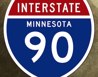 Op de afbeelding: Een blauw en rood interstate-snelweg bord met witte tekst. Het bord staat "INTERSTATE MINNESOTA 90".