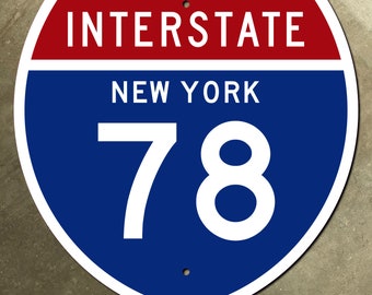 Op de afbeelding: Een blauw en rood interstate-snelweg bord met witte tekst. Het bord geeft "Interstate New York 78" aan.