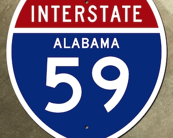 May include: A metal Interstate 59 road sign. The sign is a shield shape with a red top section that reads "INTERSTATE" in white letters. The middle section is blue with "ALABAMA" and the number "59" in white. The sign has two small holes.