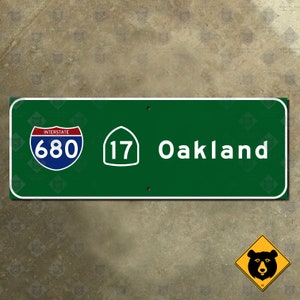 May include: Green highway sign with white text and numbers. The sign reads "Interstate 680" and "17 Oakland".