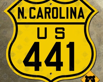Könnte beinhalten: Ein gelbes und schwarzes US-Straßenschild mit dem Text "N. CAROLINA US 441".
