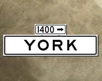 Könnte beinhalten: Ein weißes Schild mit schwarzem Text und einem schwarzen Pfeil, der nach rechts zeigt. Das Schild zeigt "YORK" und "1400" über dem Wort "YORK".