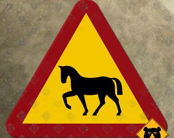 Könnte beinhalten: Ein dreieckiges Verkehrsschild mit gelber Mitte und einer schwarzen Pferdesilhouette in der Mitte. Das Schild hat einen dicken roten Rand und zwei kleine Löcher oben und unten zur Befestigung. Ein kleines gelbes Rautenlogo mit einem Bären.