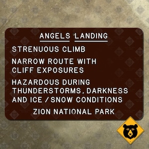 Könnte beinhalten: Ein rechteckiges braunes Schild mit weißem Text. Es zeigt "ANGELS LANDING" und warnt vor einem "ANSTRENGENDEN AUFSTIEG" und "FELSENEXPOSITIONEN". Es warnt auch vor gefährlichen Bedingungen. Ein gelbes Bärenwarnschild befindet sich in der Ecke.
