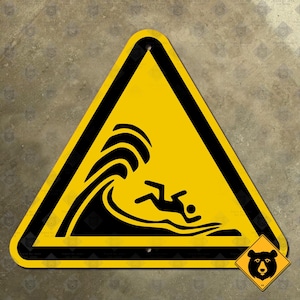 May include: Yellow triangular warning sign with a black border. The sign depicts a black silhouette of a person being swept away by a large wave. The sign has a black bear silhouette in the lower right corner.