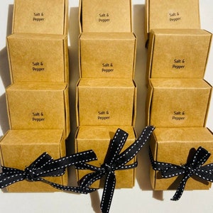 May include: Nine small brown cardboard boxes with black and white ribbon tied around them. Each box has the text "Salt & Pepper" printed on the front.