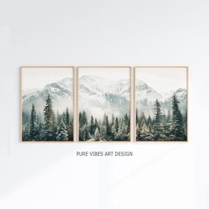 Könnte beinhalten: Drei gerahmte Landschaftsdrucke mit einer schneebedeckten Bergkette und immergrünen Bäumen. Das Kunstwerk hat eine gedämpfte Farbpalette aus Weiß, Grau und Grün. Der Text "PURE VIBES ART DESIGN" ist unten aufgedruckt.
