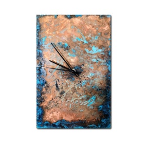 May include: A square copper clock with a blue and brown marbled design. The clock has black hands and a white face.